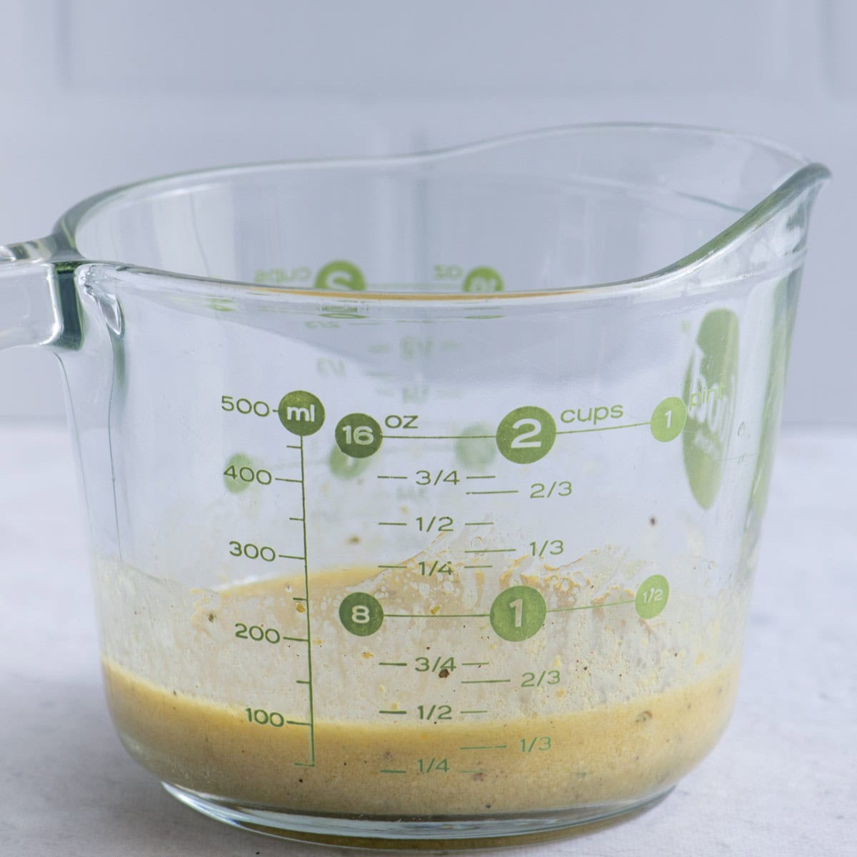 Dressing ingredients in a glass measuring cup after combining.