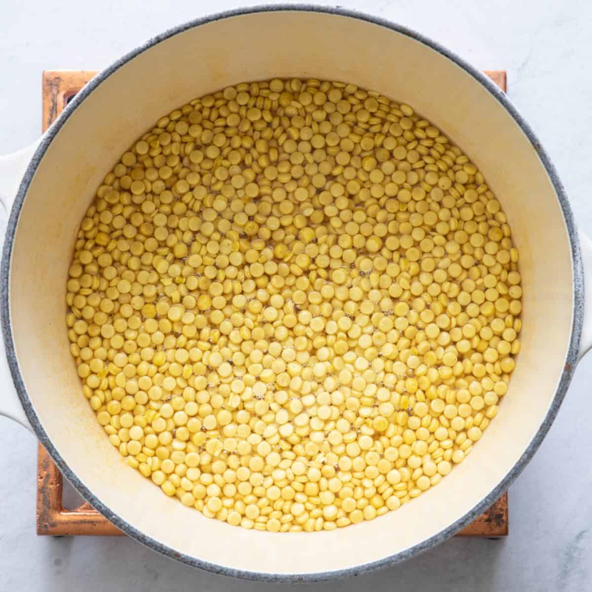 Couscous and broth in skillet before cooked.