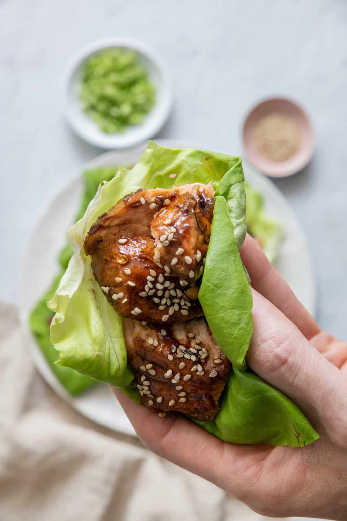 Close up of salmon lettuce wraps topped with sesame seeds.