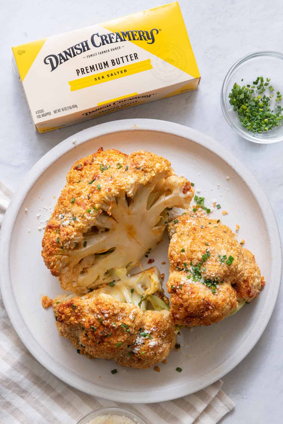 Large white serving dish with cauliflower that has been roasted with a seasoned blend of Danish Creamery butter.