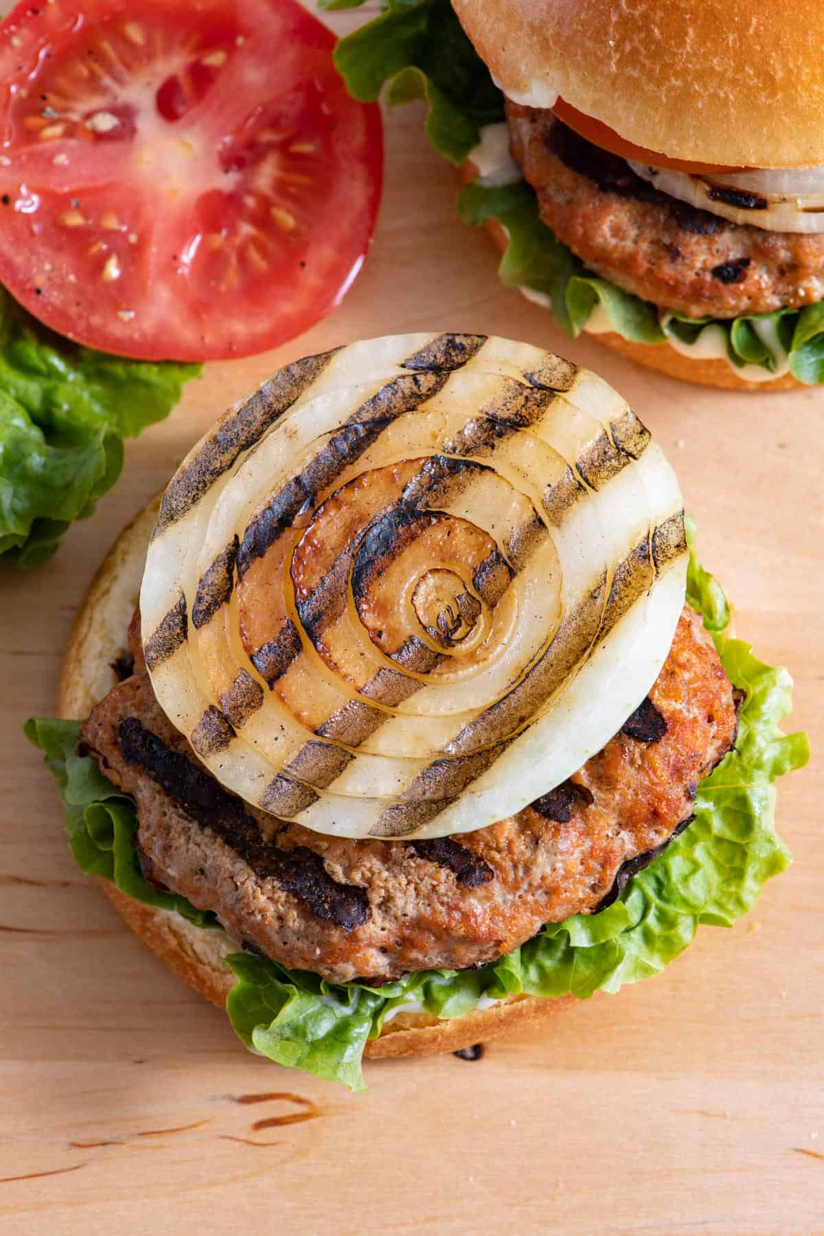 Turkey burger without top bun showing grilled onion ring.