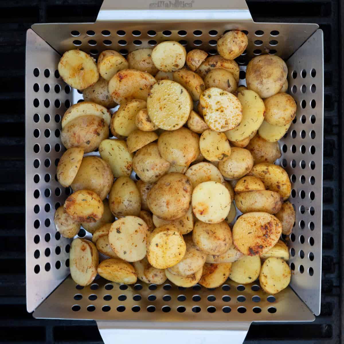 Potatoes on grill basket before grilling.