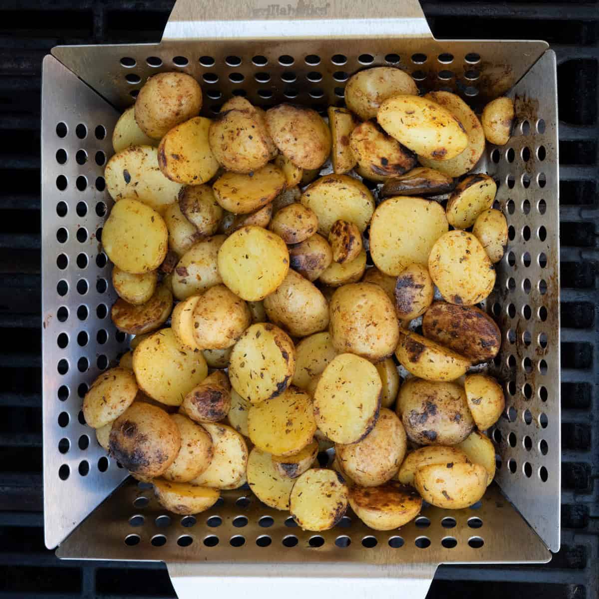 Potatoes on grill basket after grilling.