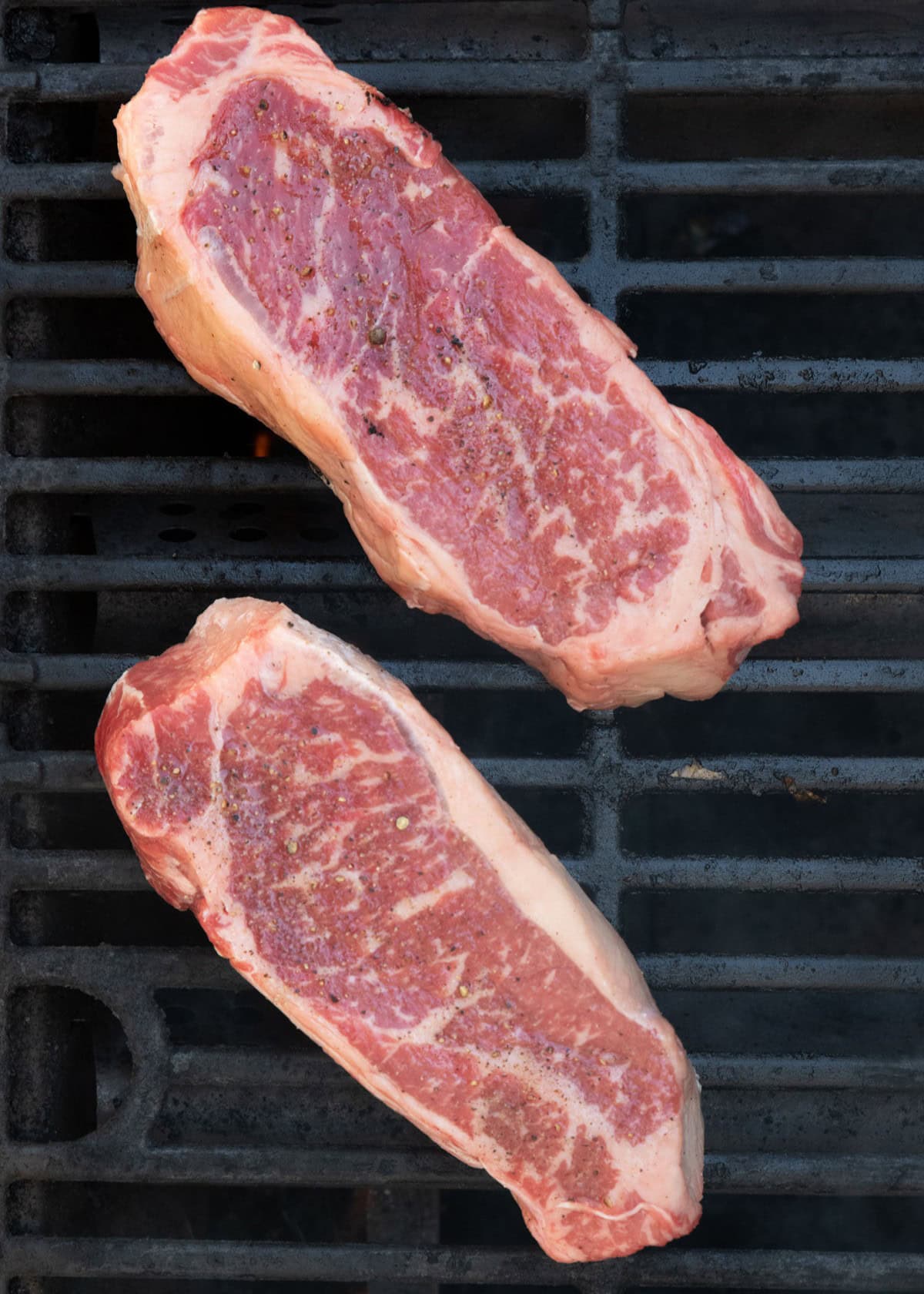 Raw steak on grill.