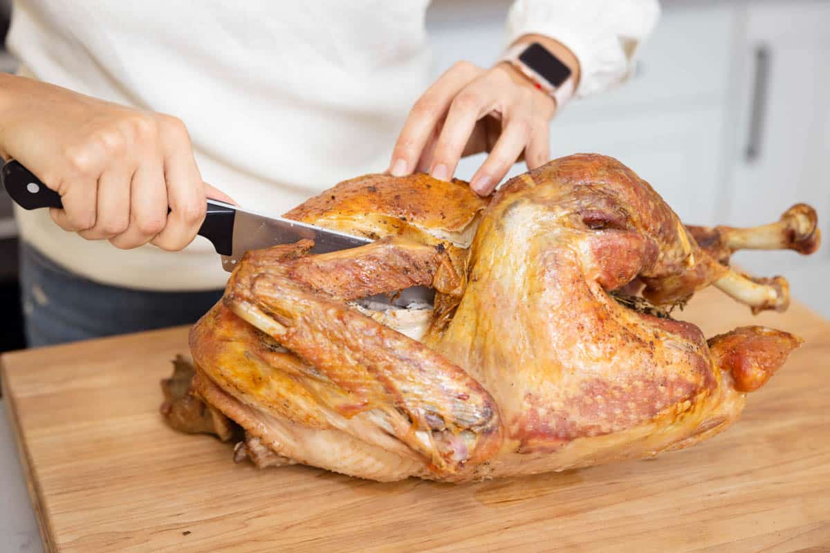 Carving knife cutting turkey on cutting board