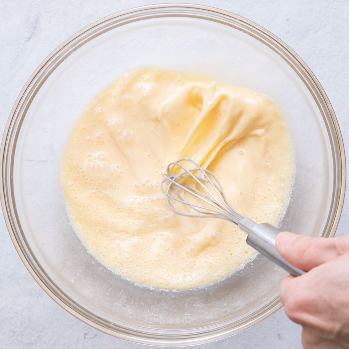 Whisking eggs, milk and butter.