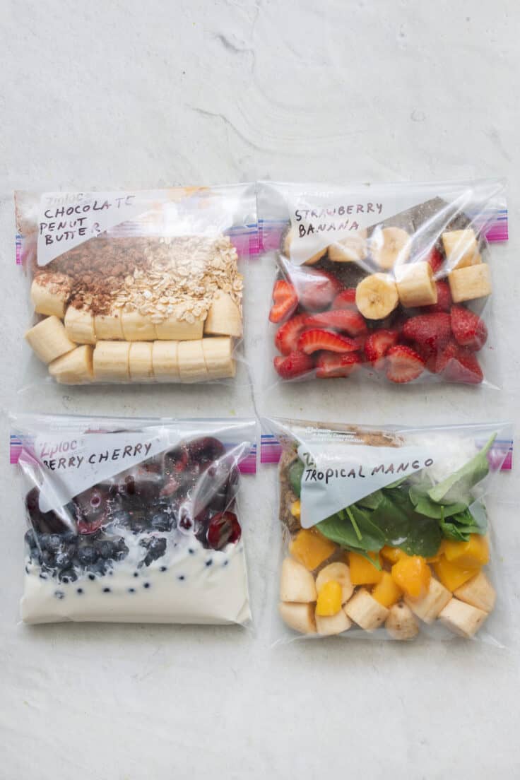 4 zip top bags with different smoothie recipe ingredients in each.