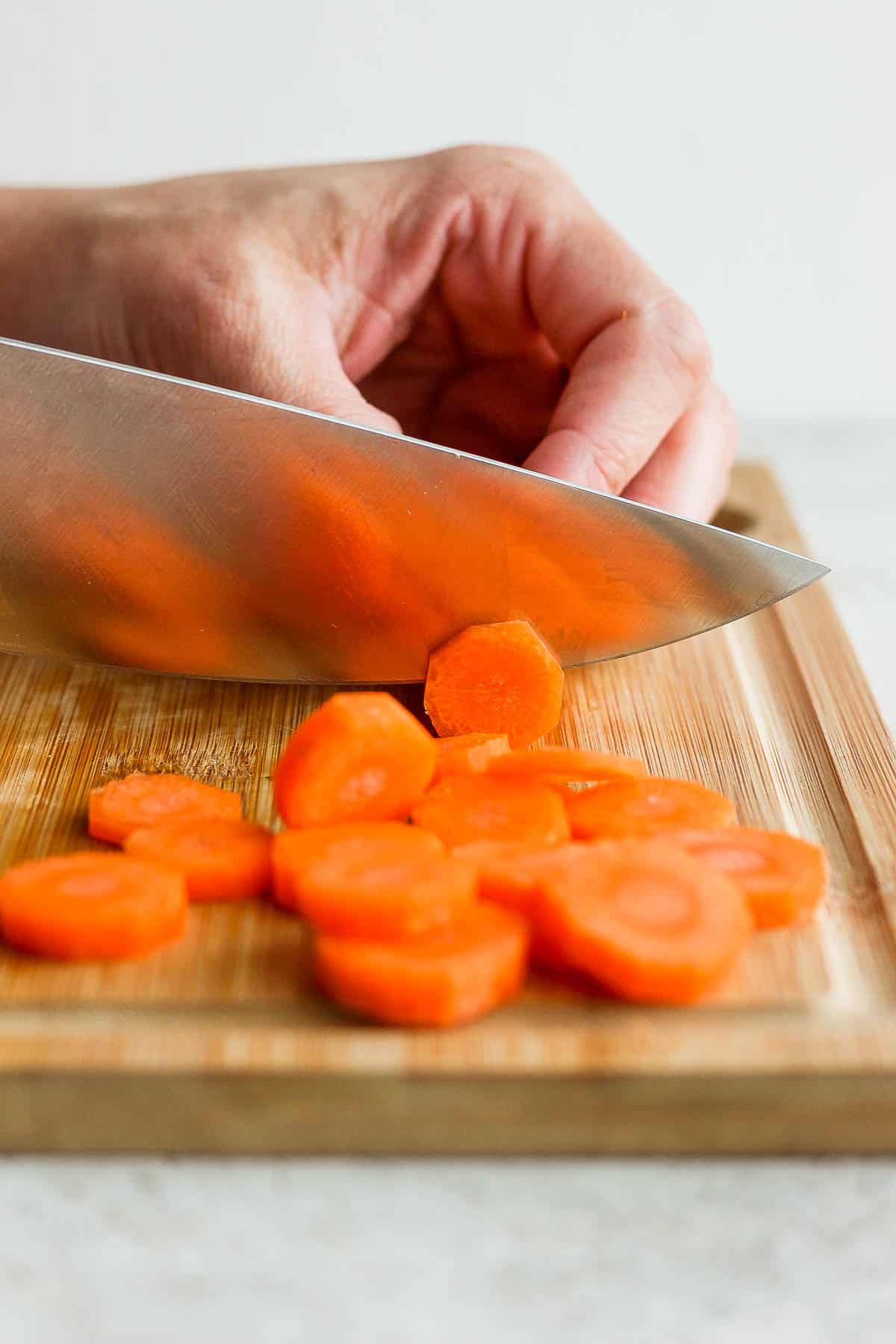 Hand cutting carrots into coins