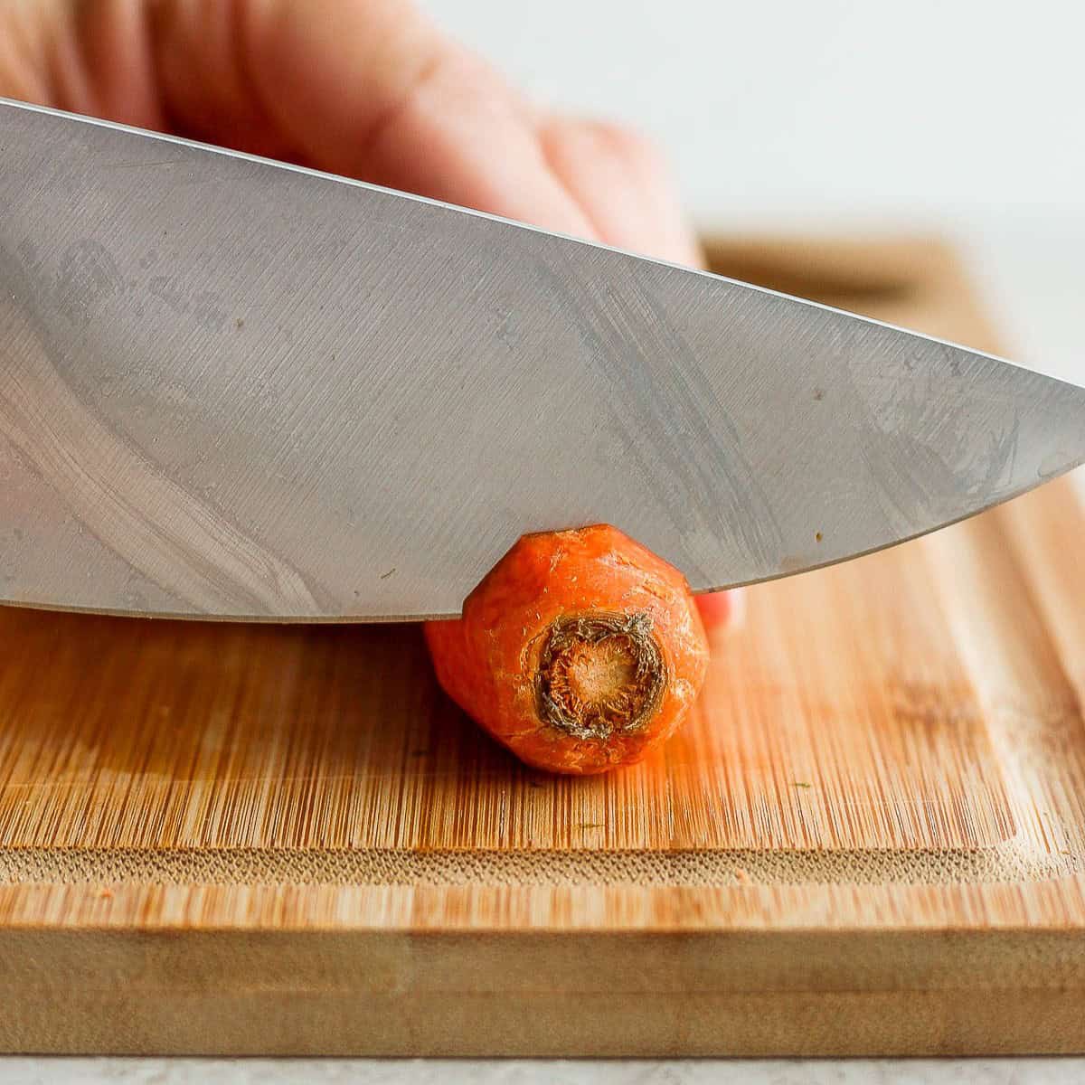 Cutting off the top of a carrot.
