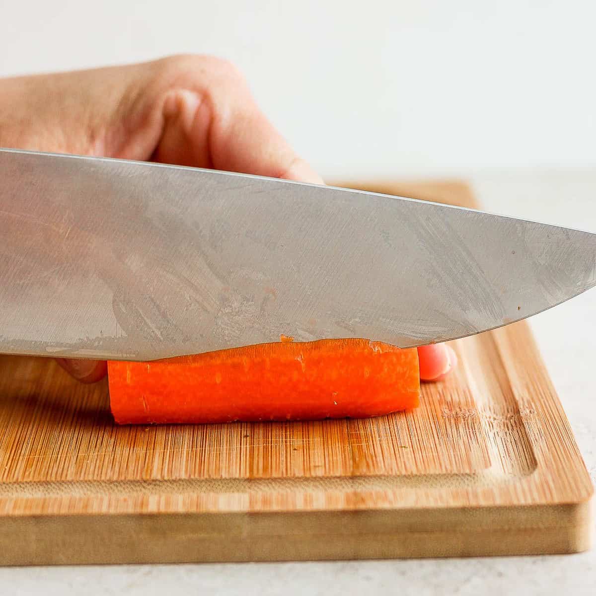 Cutting off the edges of a carrot to have a rectangle.