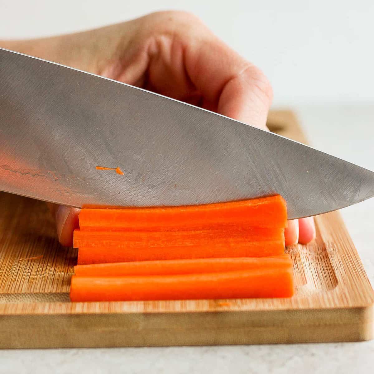 Cutting carrots into strips.