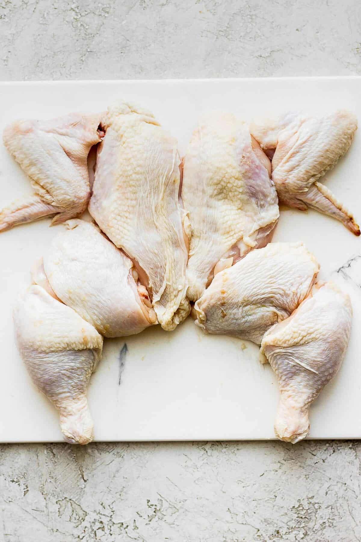 8 pieces cup up flat on cutting board arranged in shape of chicken.