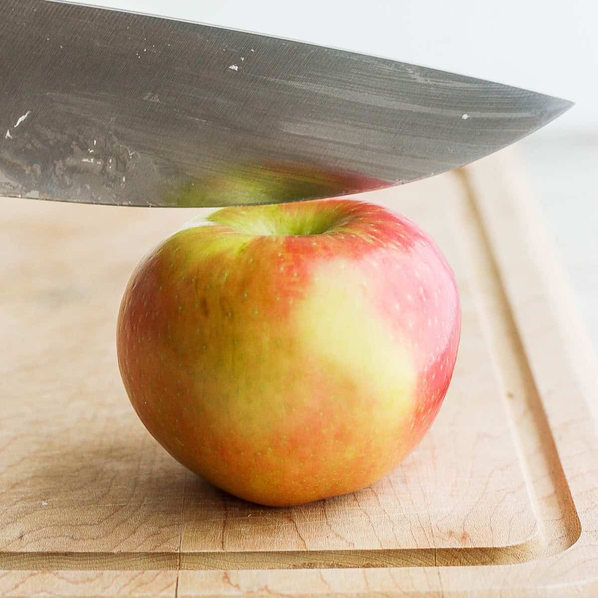 Sharp knife sitting ¼ inch away from stem before cutting.
