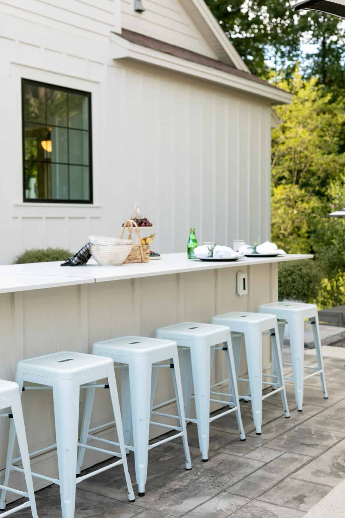 Outdoor white bar stools lined up at the kitchen counter outdoor