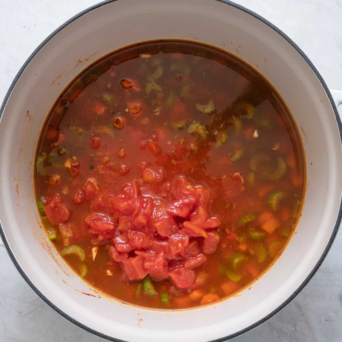 Broth and tomatoes added to the pot.