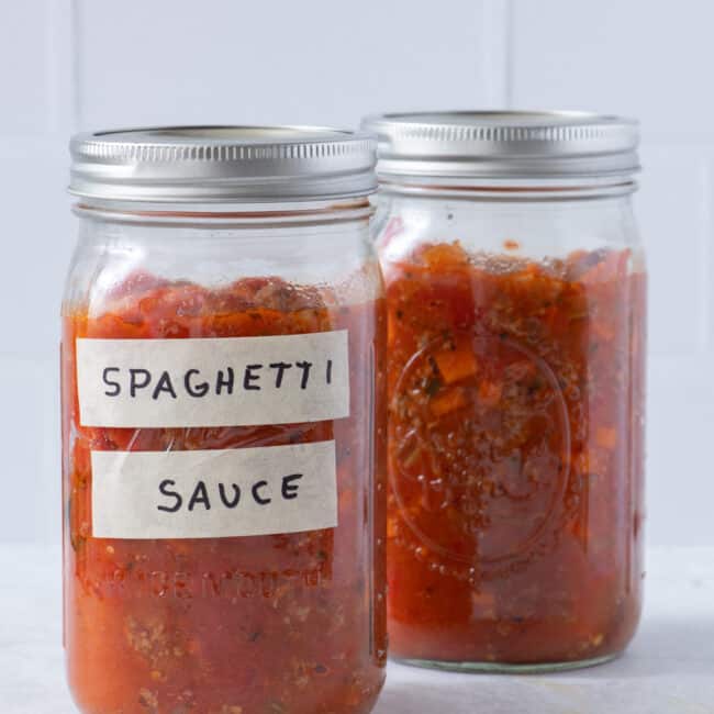 Spaghetti sauce in two large mason jars one with a label.