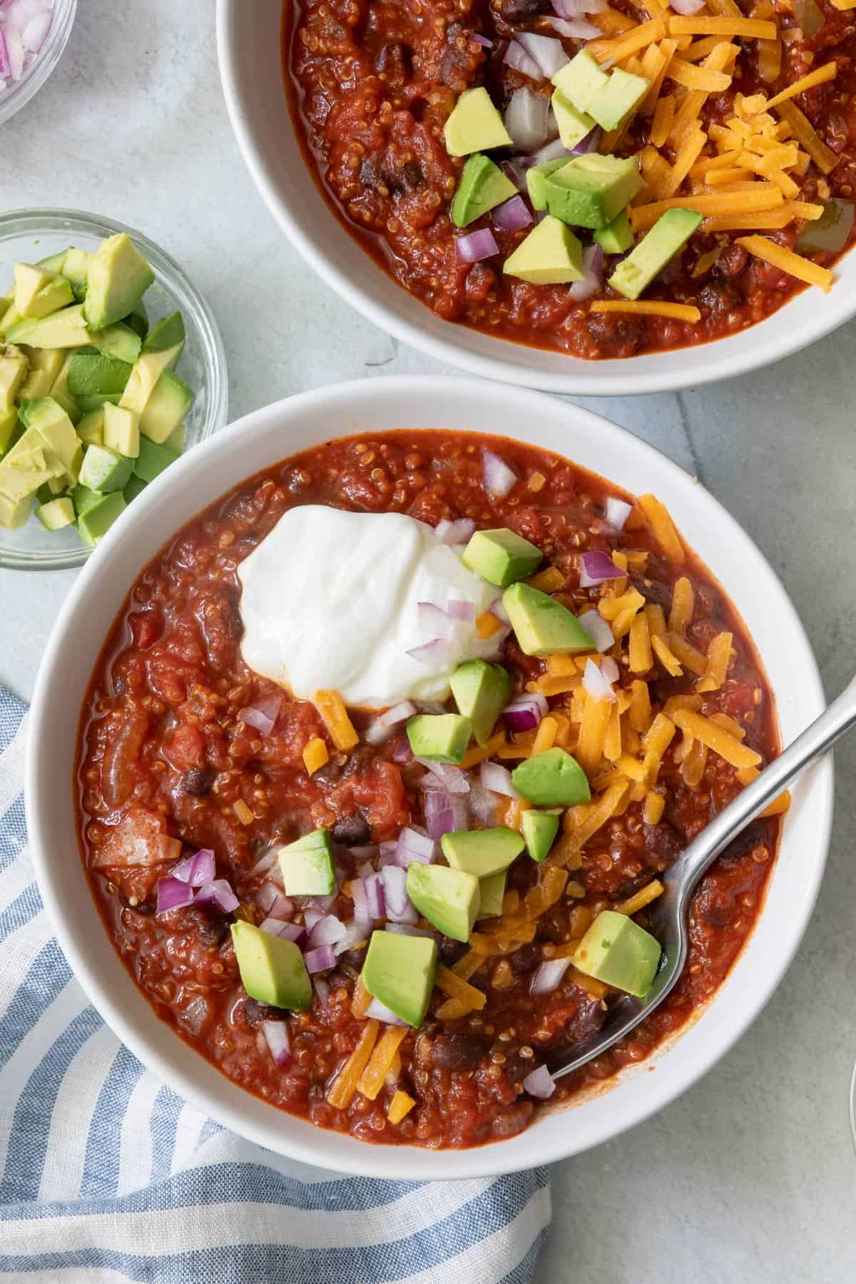 Overhead shot of chili in a white bowl with another filled bowl off to the side.