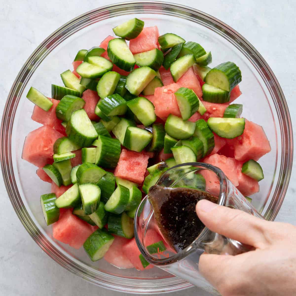 Pour dressing on top of watermelon and cucumbers..