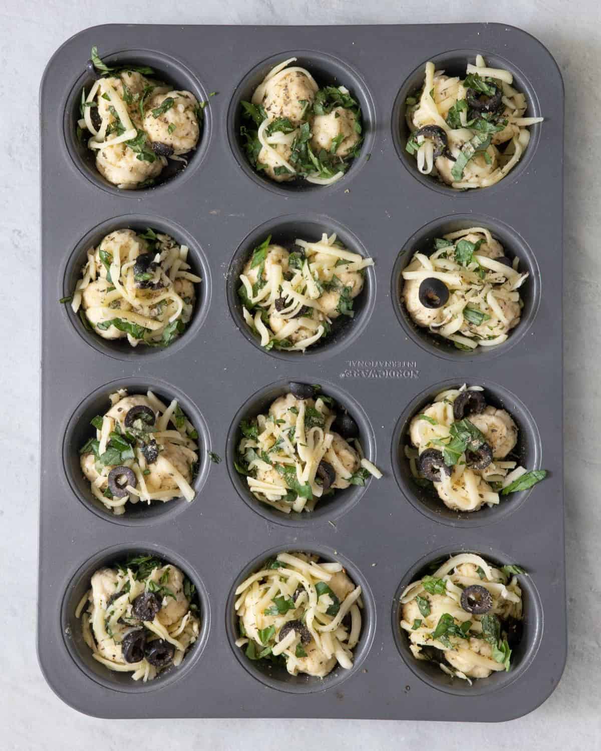 Pizza bites in a cupcake tin before they bake.