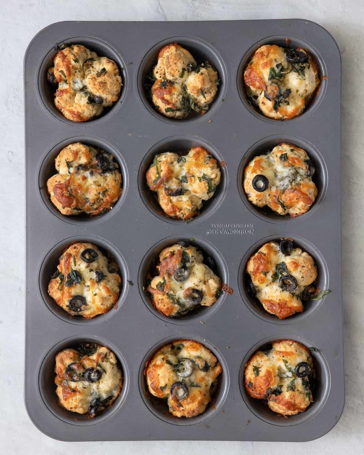 Pizza bites in a cupcake tin after they are baked.
