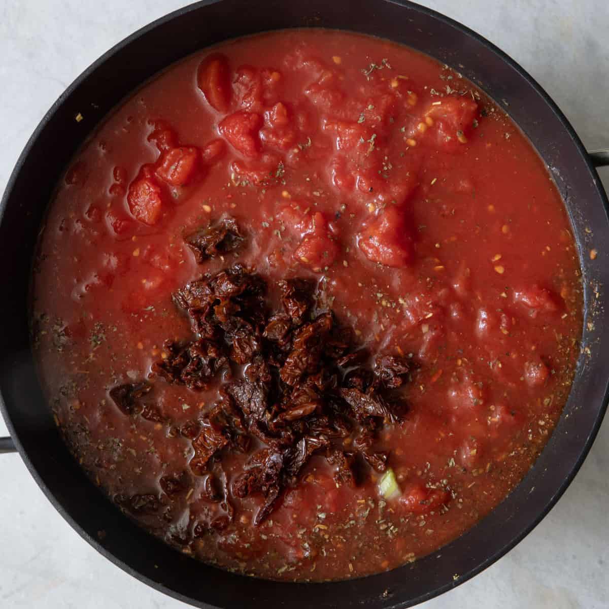 Sun-dried tomatoes and whole peeled tomatoes added in.
