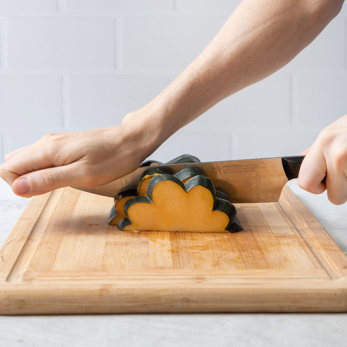 : Squash cavity side down, starting to slice across ridges.
