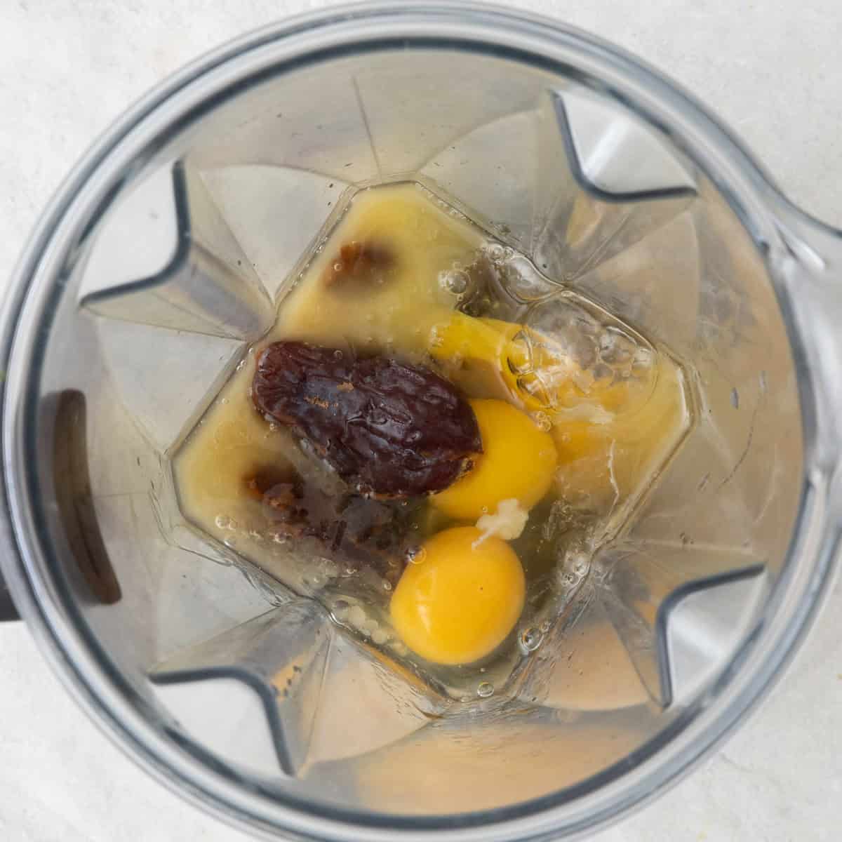 Blender with eggs, dates, maple syrup, brown sugar, butter, vanilla and salt before being processed.