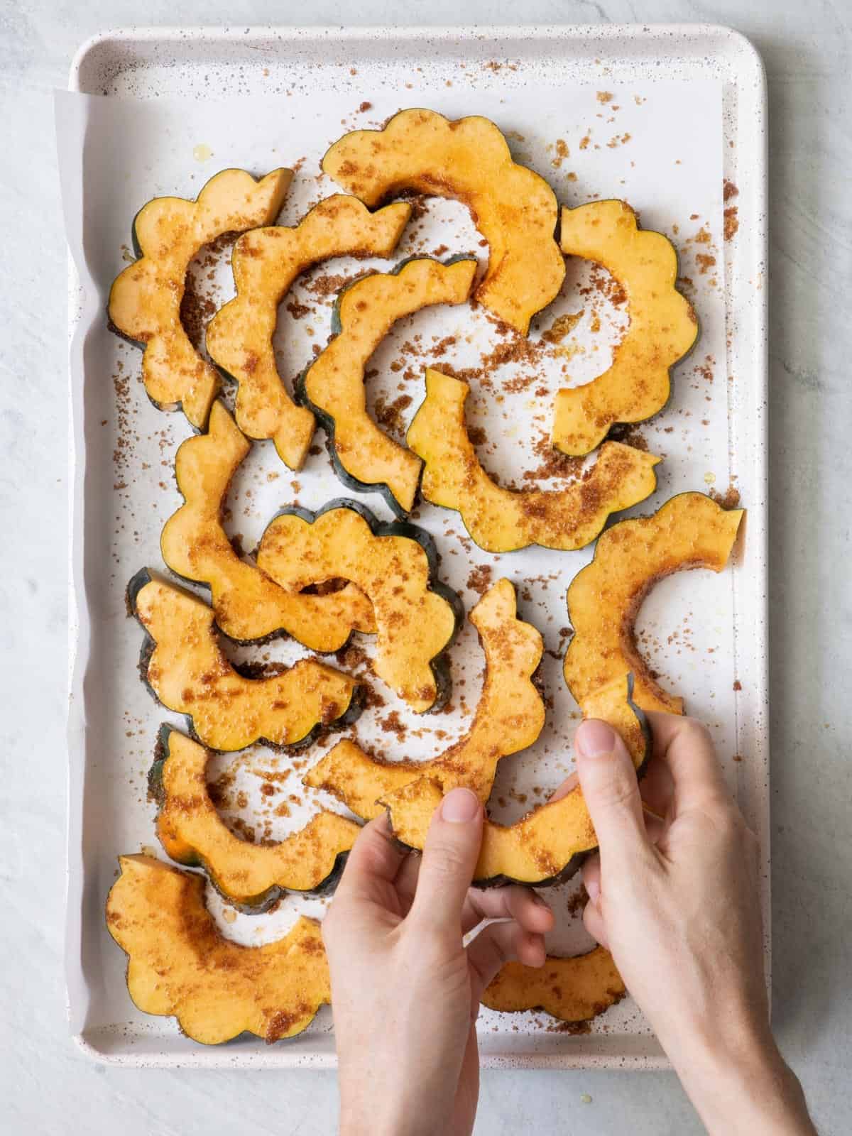 Brushing seasoning and olive oil onto squash.
