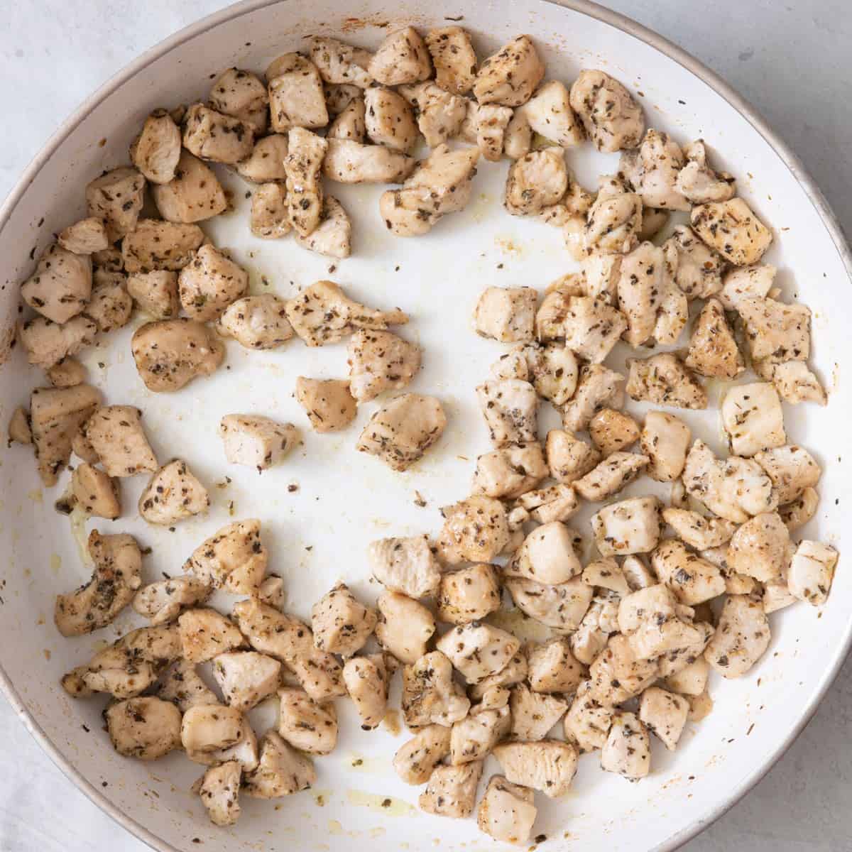 Chicken and seasoning on skillet after cooked.