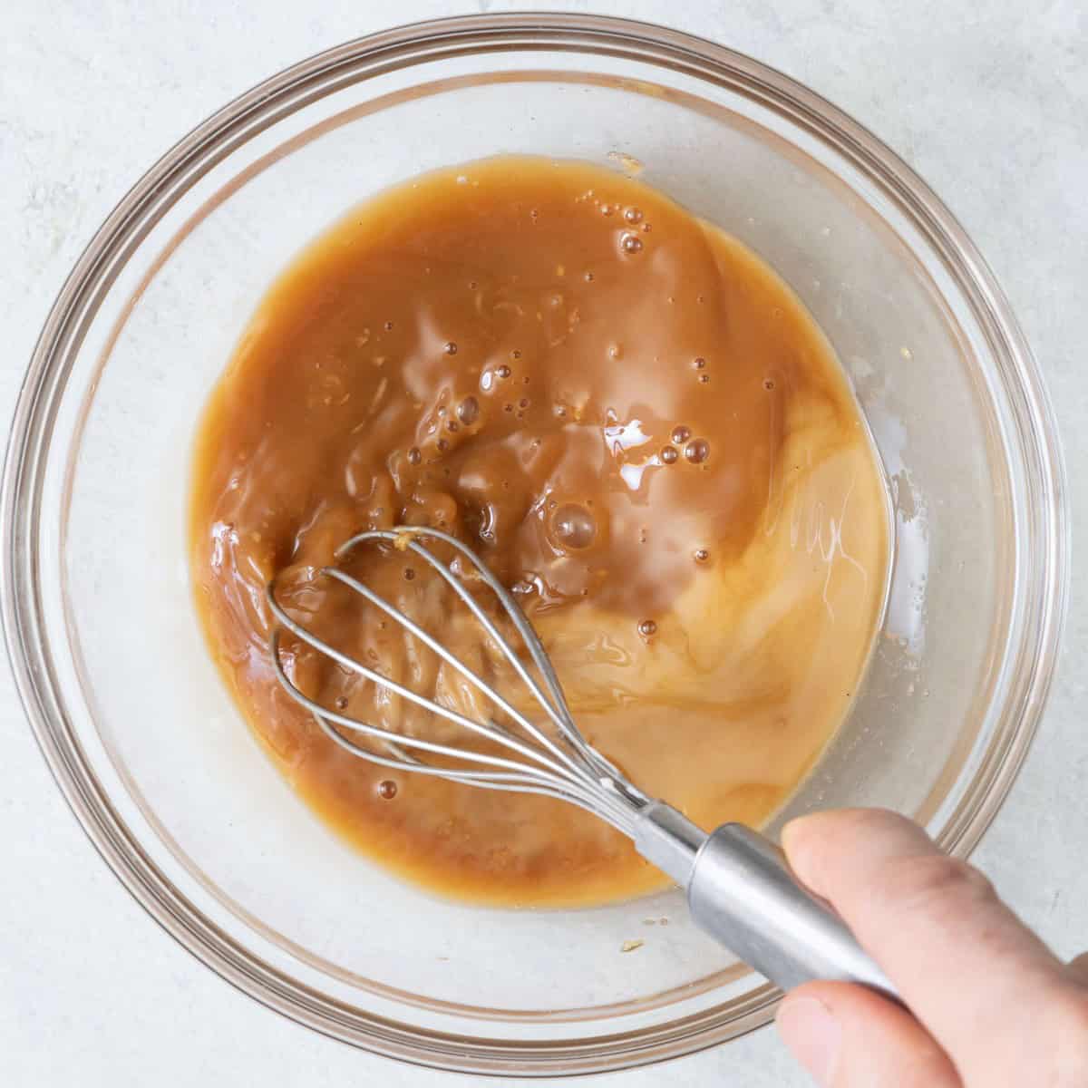 Whisking cornstarch into sauce.