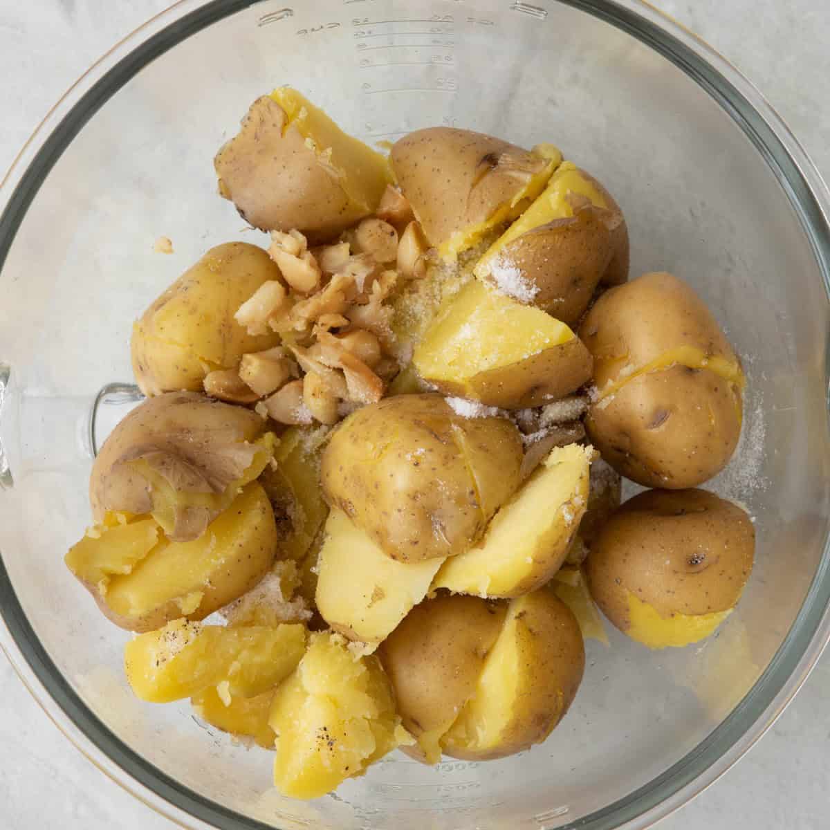 Drained and cooked potatoes in stand mixer with paddle attachment with roasted garlic and remaining seasoning.