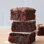 Stack of 3 brownies with a small square of parchment between each piece.