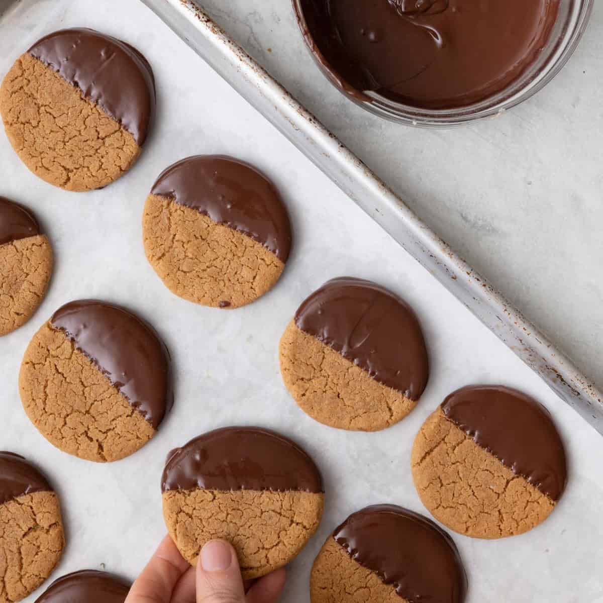 Placing cookie on parchment paper lined baking sheet, with other cookies on there.