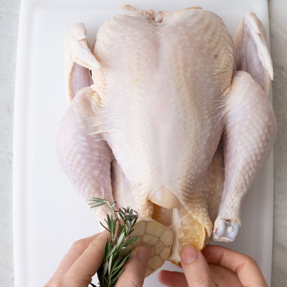 Rosemary and lemon going inside cavity of chicken.