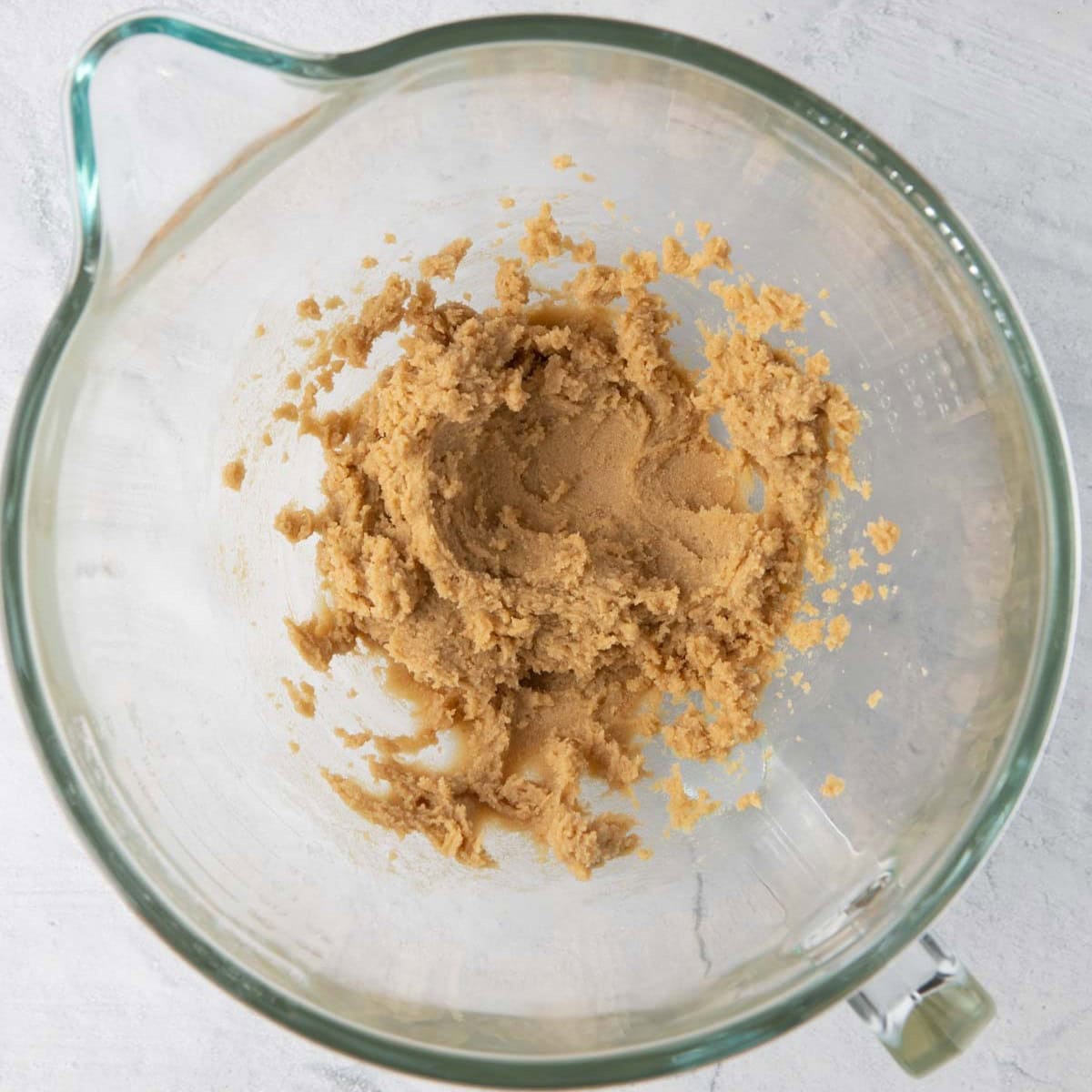 Sugar and butter in a bowl of a stand mixer.