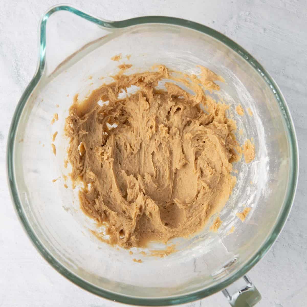 Cookie dough in the bowl of a stand mixer.