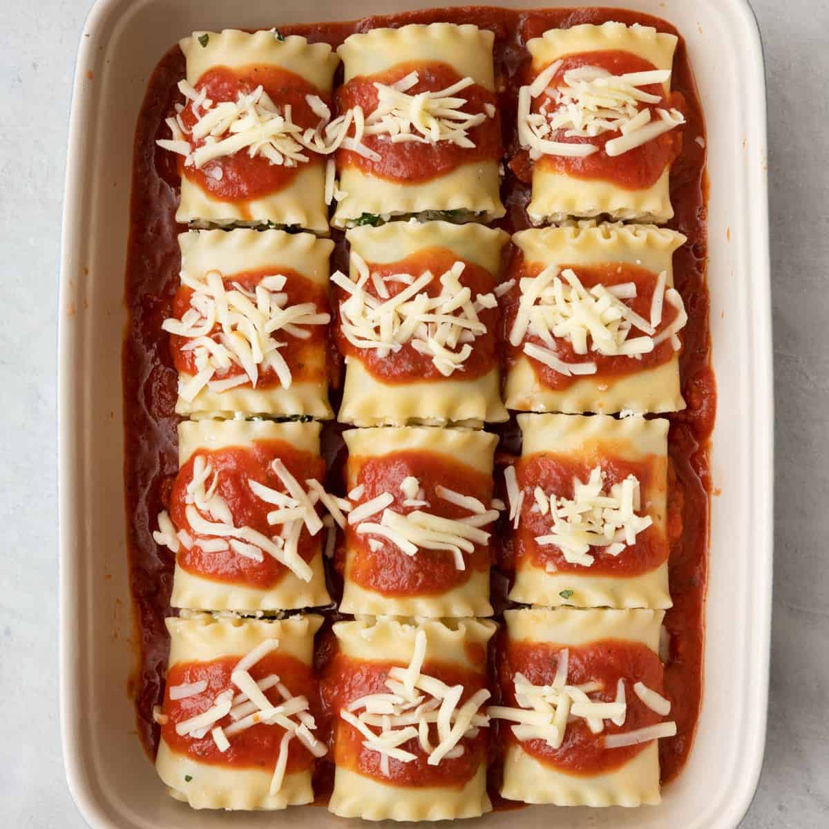 Marinara sauce on top sprinkled with mozzarella before being baked.