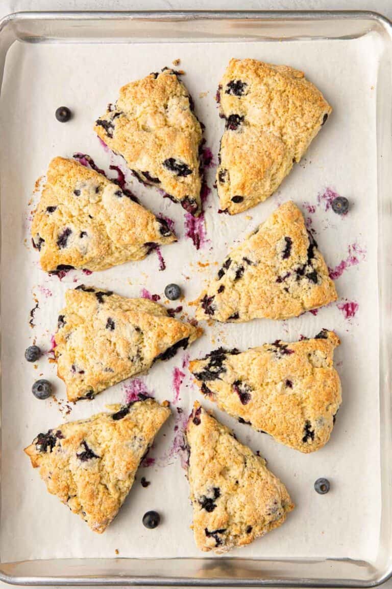 Blueberry scones on parchment lined baking sheet.