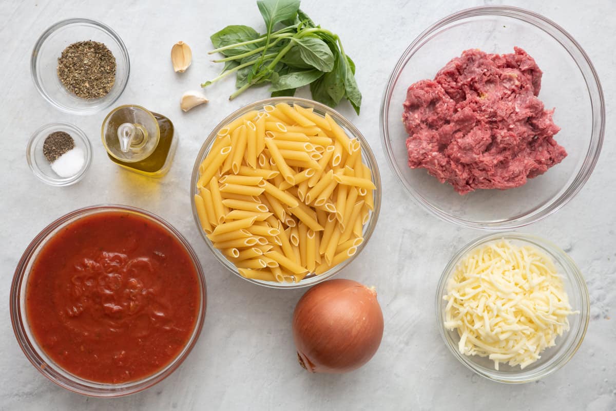 Ingredient for recipe: Italian seasoning, salt and pepper, oil, garlic cloves, marinara, dry pasta, raw ground beef, onion, and shredded cheese.