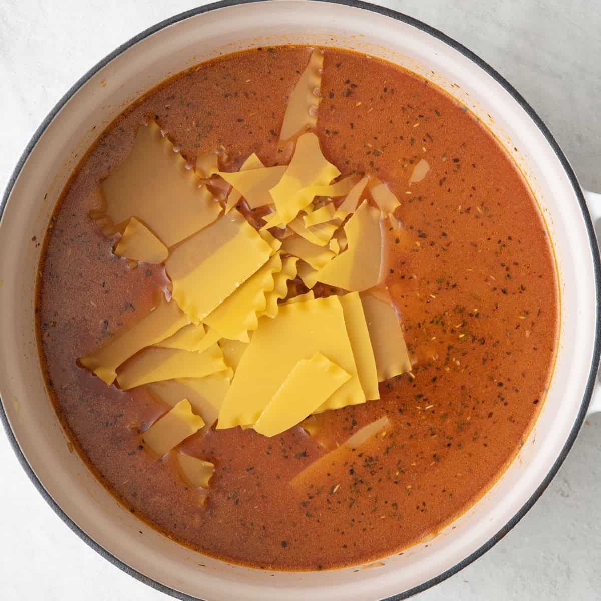 Uncooked lasagna noodles added on top before stirred in.