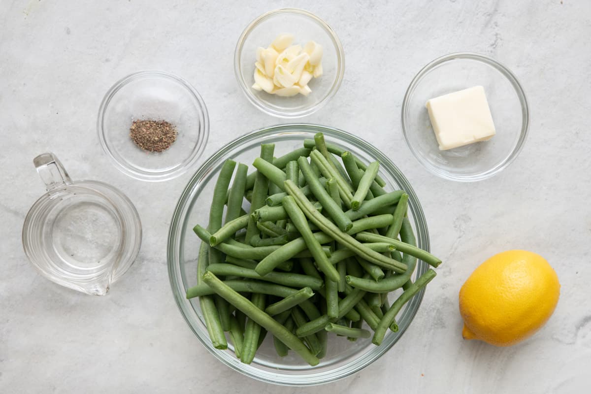 Ingredients for recipe: fresh green beans, salt and pepper, water, butter, sliced garlic, and lemon.