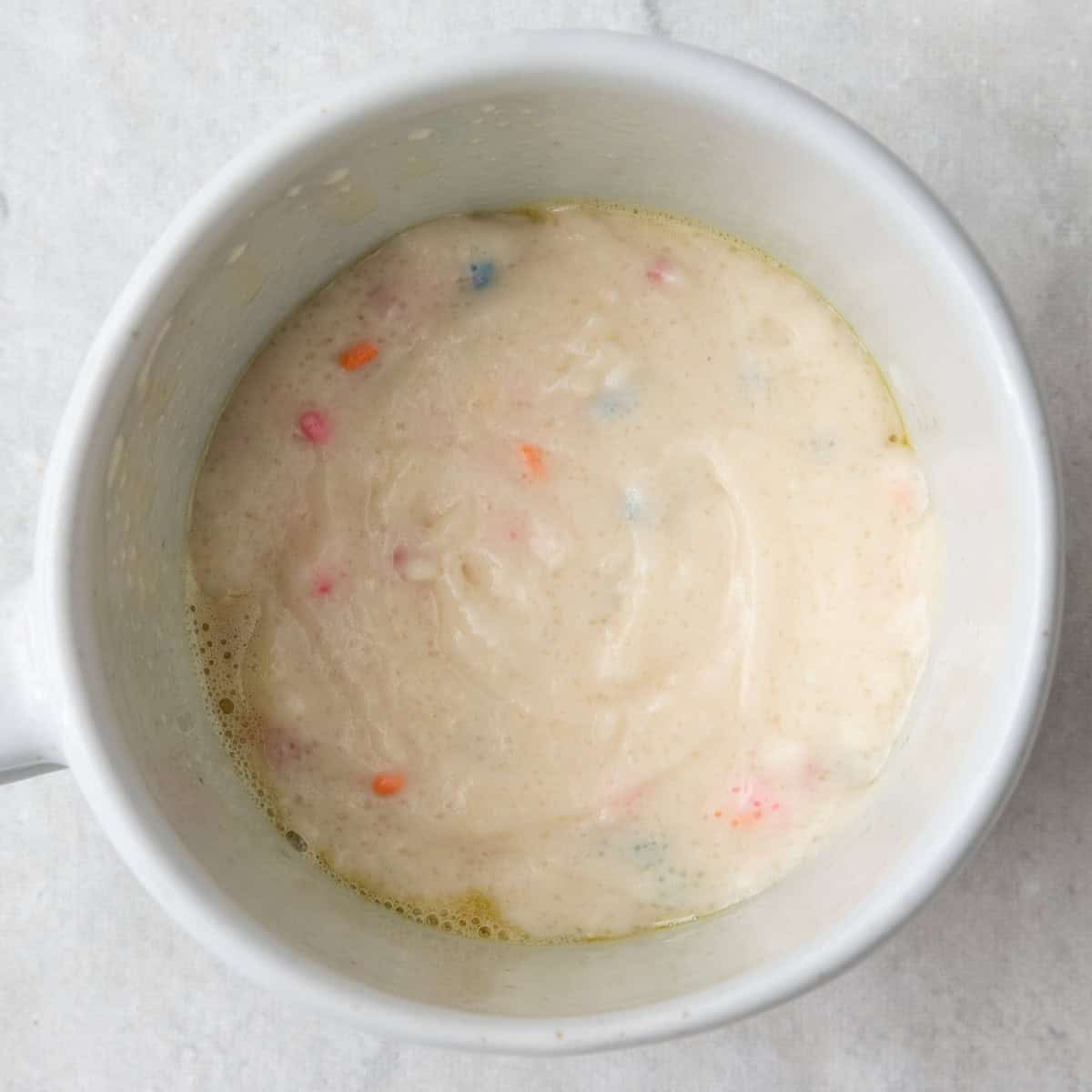 Stirred together ingredients in a mug for the vanilla cake.
