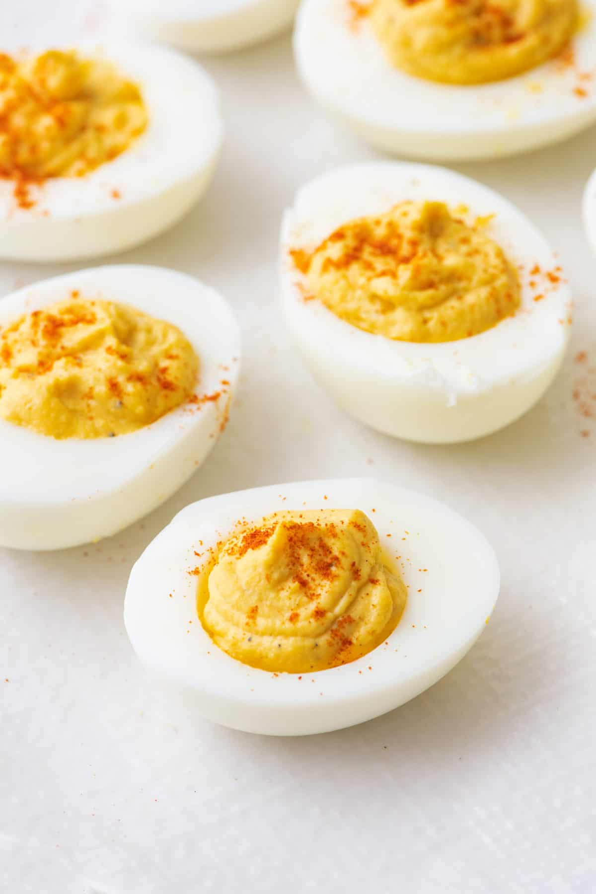 Close up side view of devilled eggs with paprika sprinkled on top.