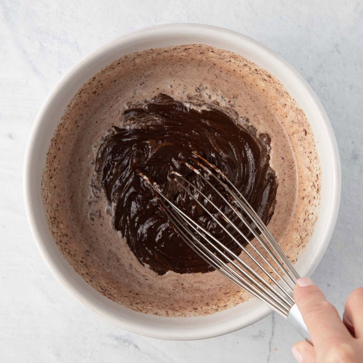 Whisking chocolate and cream together.