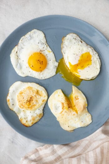 4 types if fried eggs on a plate: sunny side up, over easy, over medium, and over hard.