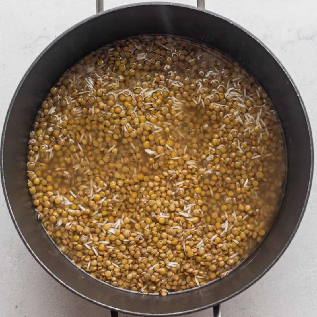 Lentils and rice stirred together in a pot.