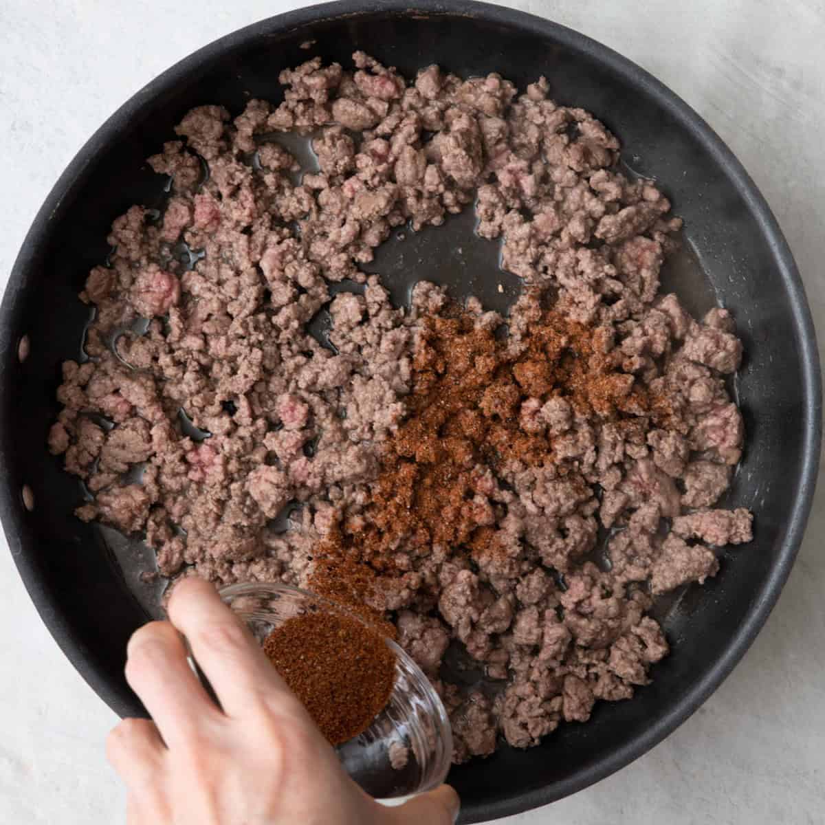 Seasoning sprinkled over cooked beef.