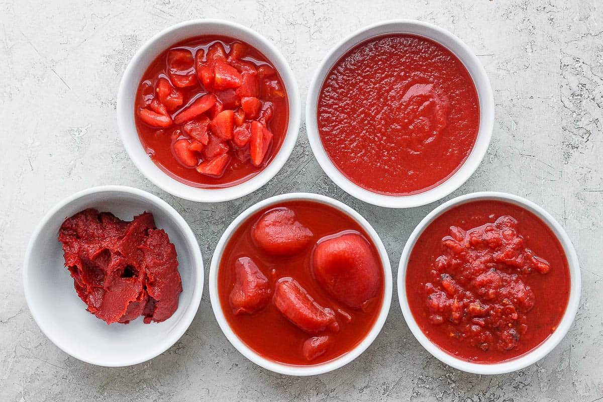 5 different canned tomatoes in bowls.