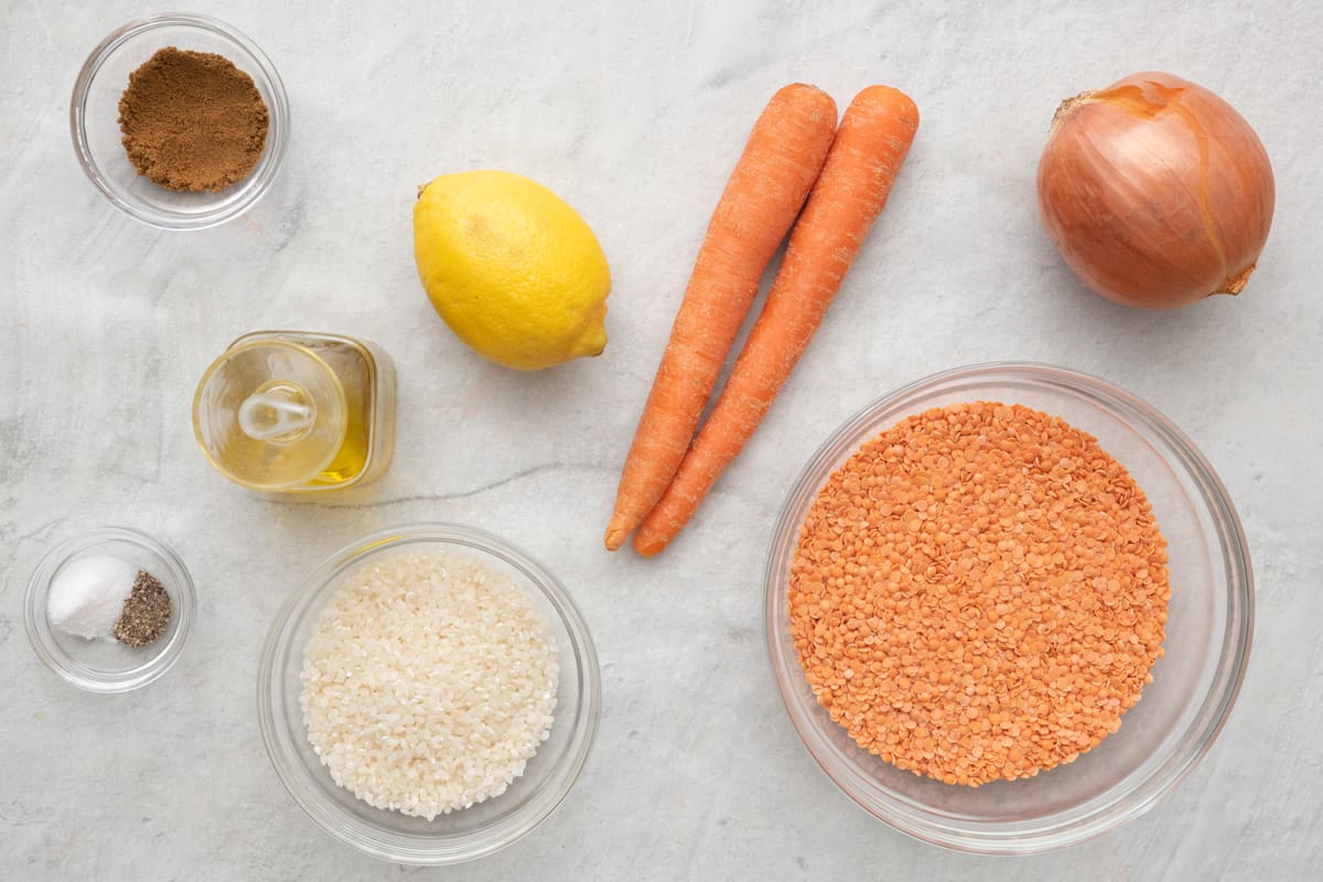 Ingredients for recipe before prepping: cumin, salt and pepper, oil lemon, rice, carrots, lentils, and onion.