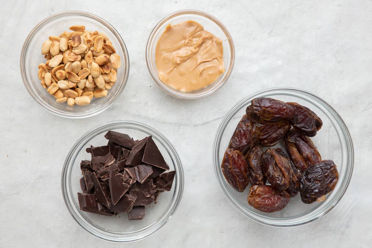Ingredients for recipe: peanuts, peanut butter, dark chocolate bar pieces, and dates.